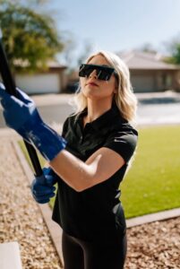 A pest control technician from Aloe Pest Control dusting the exterior of a home in Mesa, AZ.