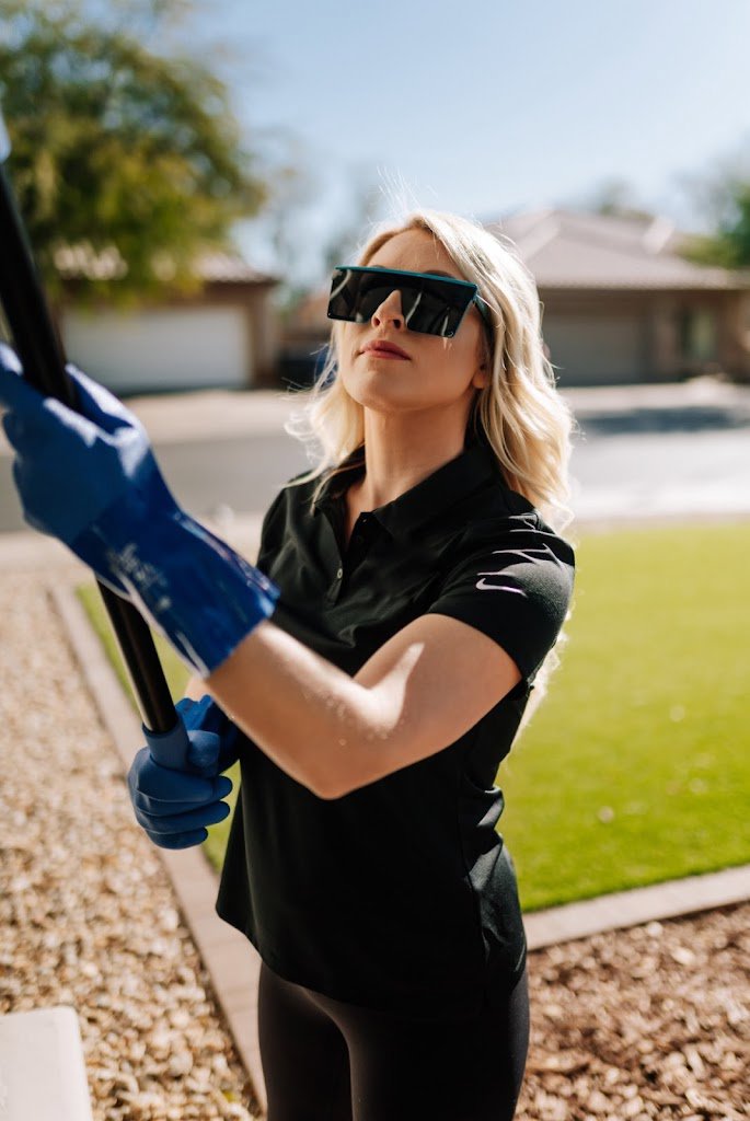 A pest control technician from Aloe Pest Control dusting the exterior of a home in Mesa, AZ.