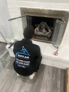 A SafeAir Duct & Chimney technician examining a fireplace during a chimney sweep service in Dallas, TX.