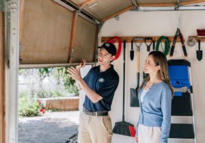 A Precision Garage Door of Charleston technician explaining a repair to a customer inside a garage in Charleston, SC.
