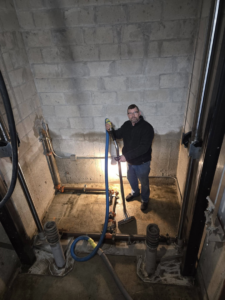A technician from Aardvark Dean Of Clean extracting water from a concrete pit in Nashua, NH.
