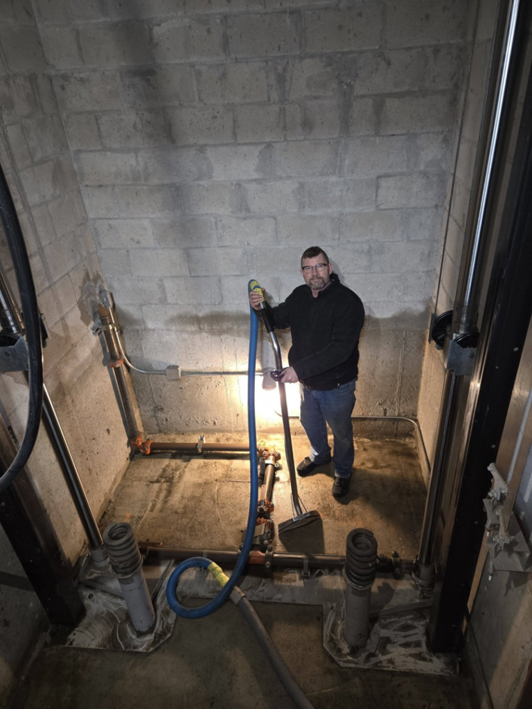 A technician from Aardvark Dean Of Clean extracting water from a concrete pit in Nashua, NH.
