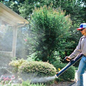 A technician from Liberty Pest Services LLC fogging bushes and landscaping for pest control in Mayflower, AR.
