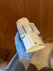 A Killer Pest Control technician holding an insect trap for pest monitoring in Post Falls, ID.