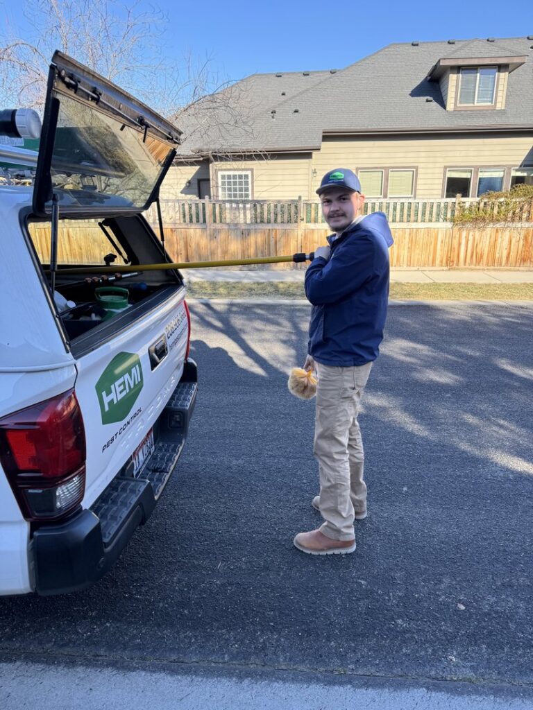 A Hemi Pest Control technician holding a trap with captured rodents, demonstrating effective wildlife control in Meridian, ID.