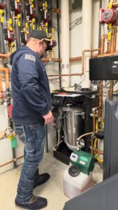 A technician inspecting a complex boiler or hydronic heating system by Utah Mechanical Heating and Air Conditioning in South Ogden, UT.
