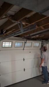 A technician from Gilliam Services LLC inspecting a garage door opener and tracks in Johnson City, TN.