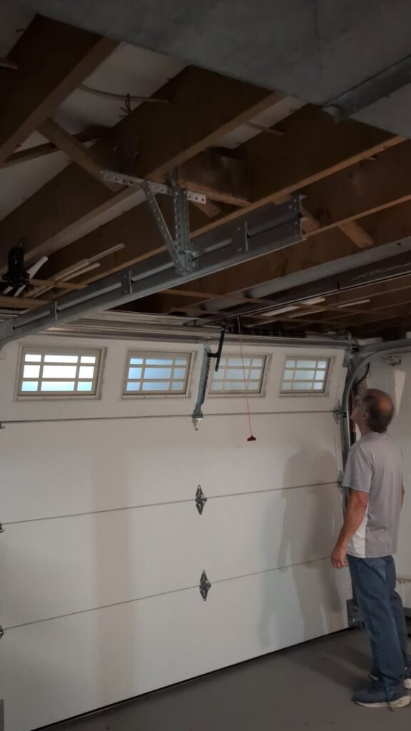 A technician from Gilliam Services LLC inspecting a garage door opener and tracks in Johnson City, TN.