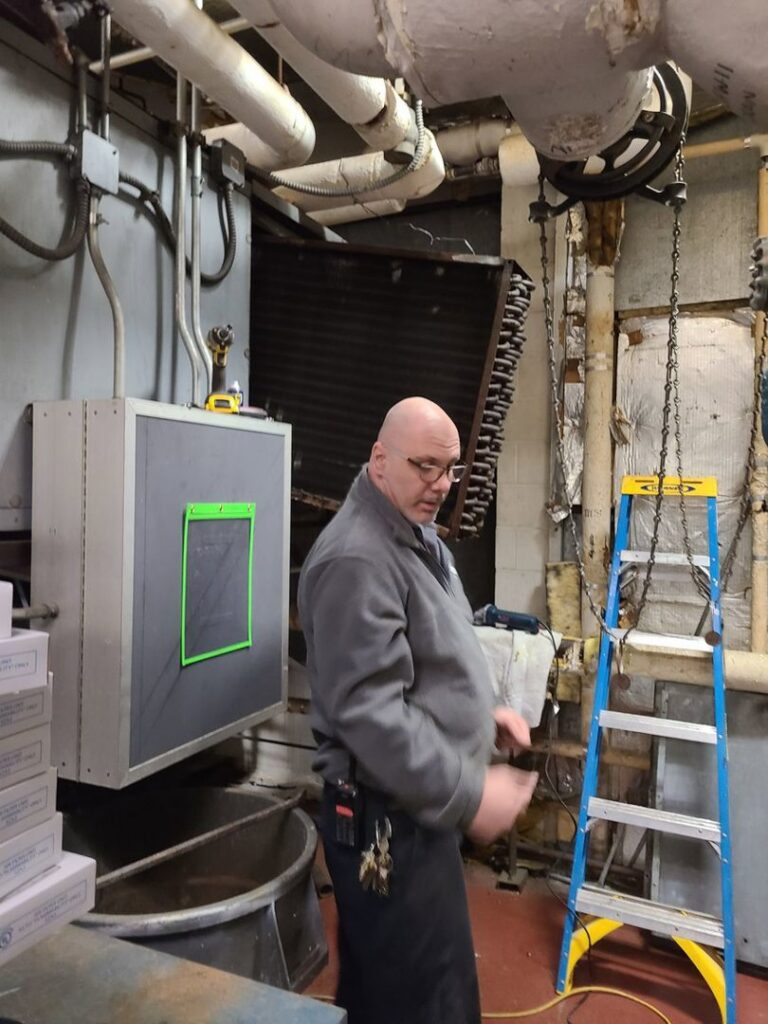 A technician inspecting an industrial refrigeration unit for Will Power Refrigeration Co in Yonkers, NY.