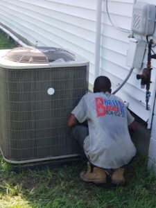 A technician from Booker Heating & Air inspecting an outdoor air conditioning unit in Richmond, VA.