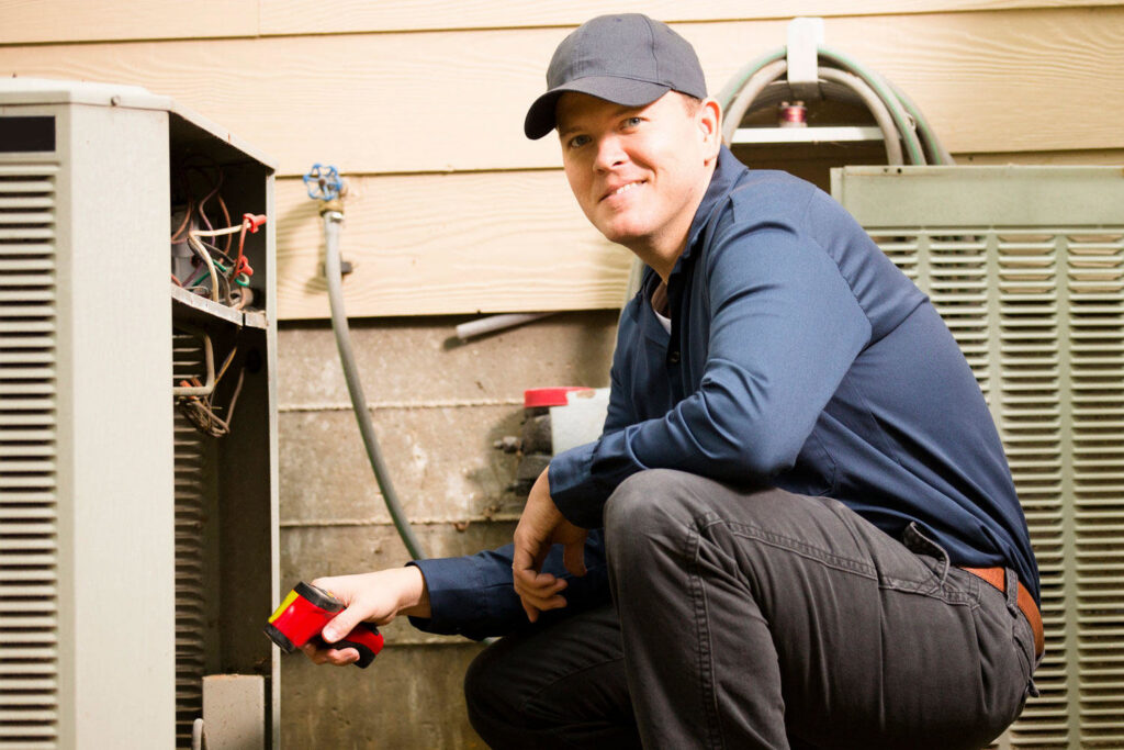 A technician inspecting an outdoor HVAC unit for Absolute Comfort Heating & Cooling, Inc. in Virginia Beach, VA.