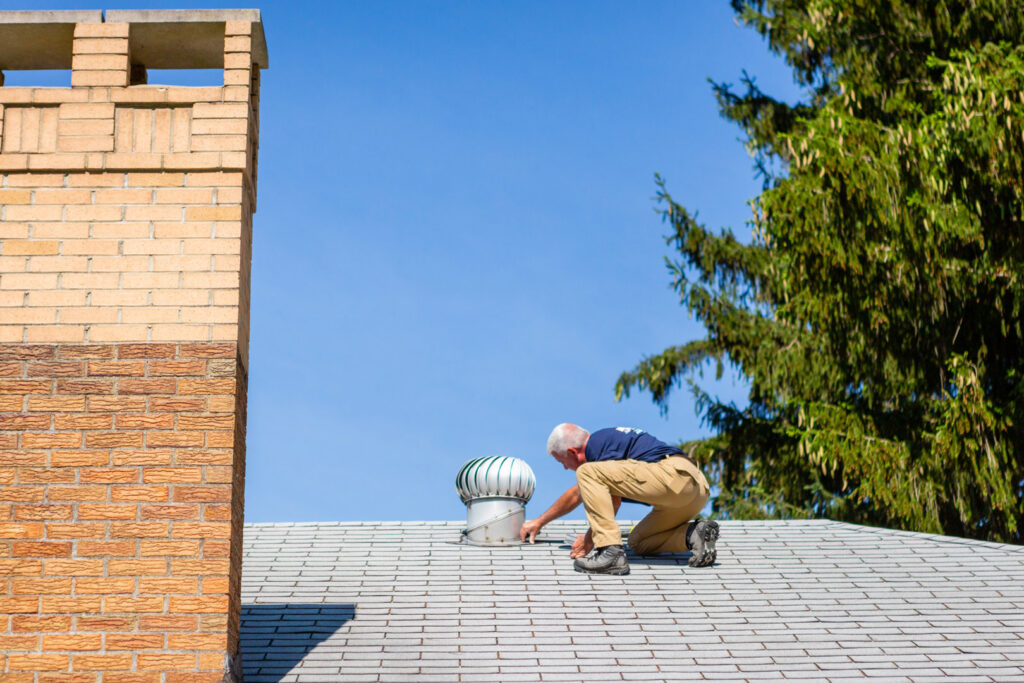 A pest control technician inspecting a roof for wildlife entry points or pest activity at Advanced Pest Control Solutions in Youngstown, OH.