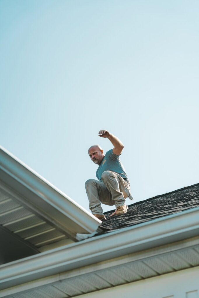 A pest control technician inspecting a roof and gutter for potential pest or wildlife entry points at Complete Pest Solutions of Canton in North Canton, OH.