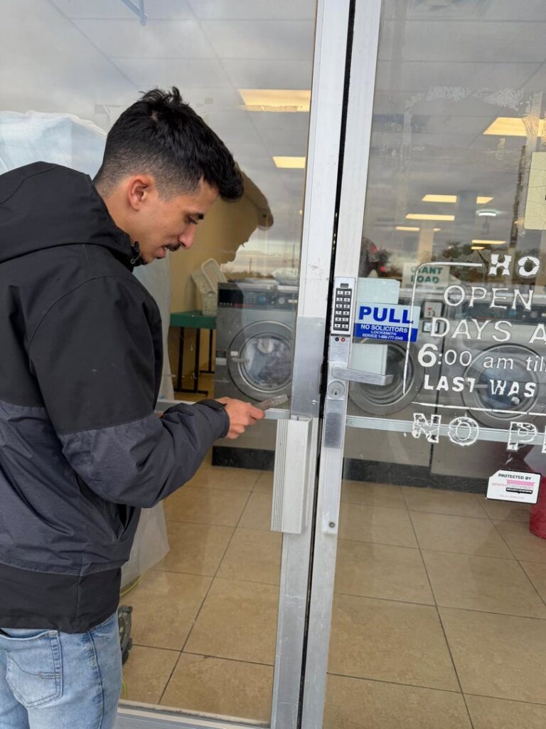 A technician from A1 Security Gate & Intercom installing an access control system on a commercial door in Dallas, TX