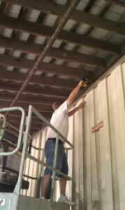 A D&J Pest Control technician in a scissor lift installing bird netting to prevent wildlife entry in Georgetown, KY.