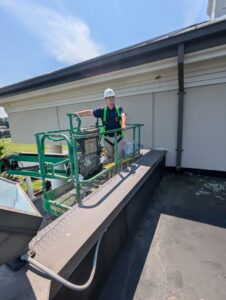 A Pest-Ops technician installing bird spikes on a building ledge for bird control services in Knoxville, TN.