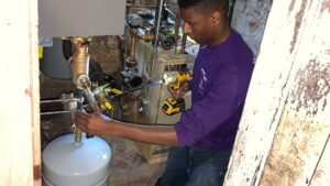 A technician from Hyper Fusion Heating & Cooling installing a new boiler system in Waterbury, CT.