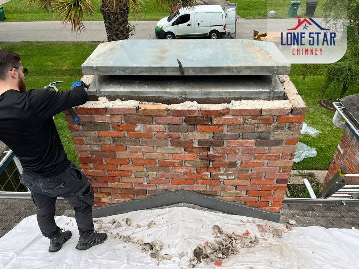 A Lone Star Chimney technician installing a new chimney cap on a brick chimney in Houston, TX.
