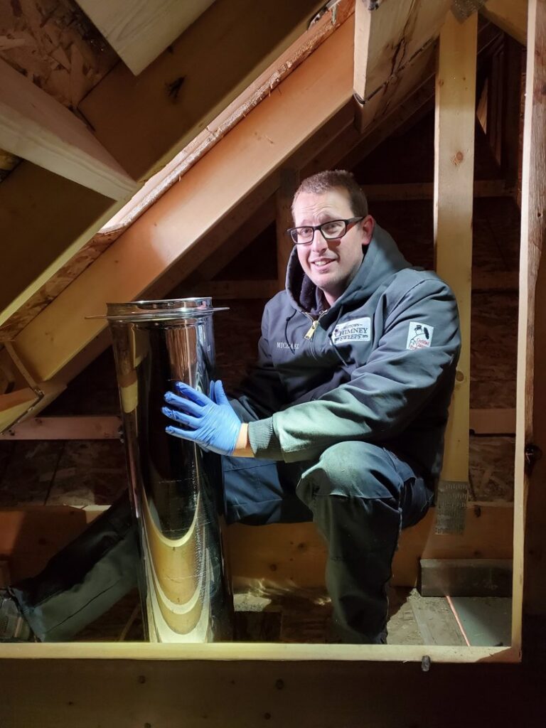 A Midtown Chimney Sweeps technician installing a chimney liner in an attic space in Golden, CO.