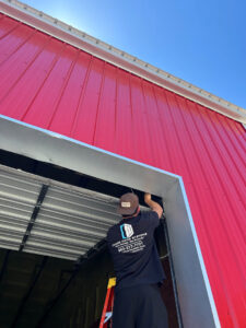 A Chase Door Systems technician installing a commercial roll-up garage door in Summerville, SC.
