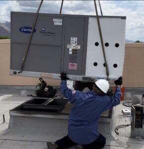 A technician installing a large commercial rooftop HVAC unit for Rite Way Heating, Cooling & Plumbing of Phoenix, AZ.