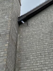A technician installing a wire mesh exclusion barrier over a roof vent to prevent wildlife entry for Eagles Eye Wildlife in Waterbury, CT.