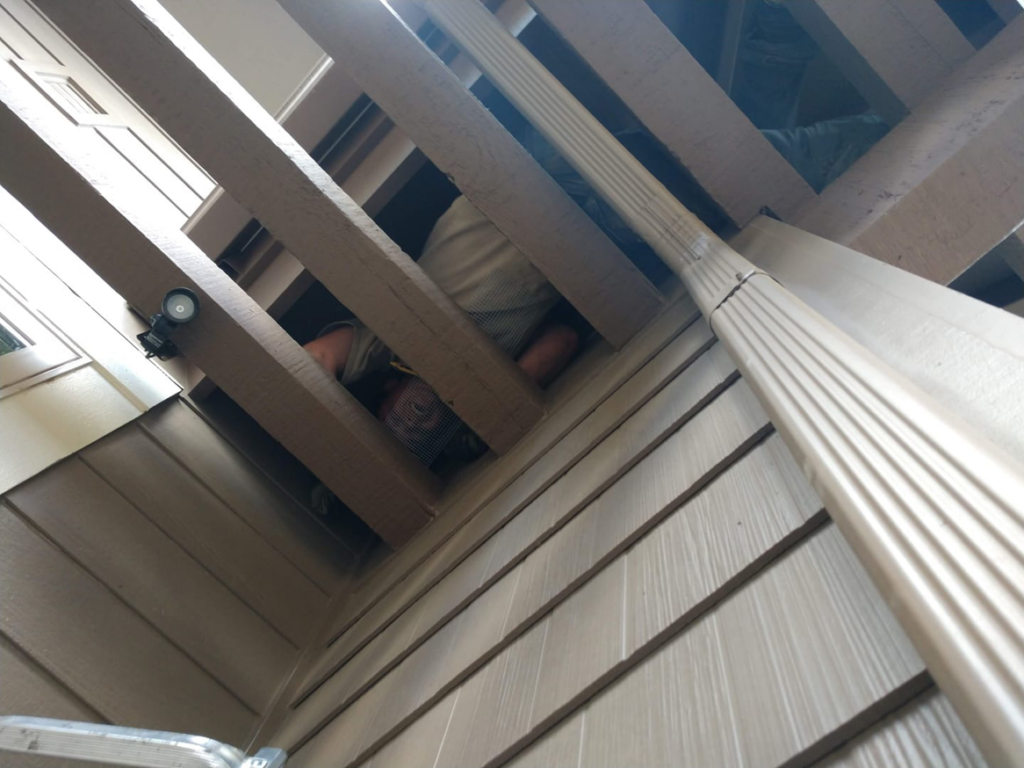 A Solid Pest Solutions technician installing exclusion mesh under a deck to prevent wildlife entry in Bend, OR.