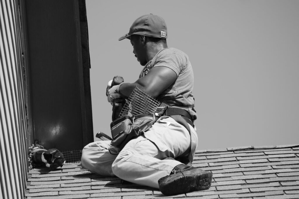 A technician installing a wildlife exclusion barrier or vent cover on a roof for Direct Pest Solutions Of Georgia, LLC in McDonough, GA.