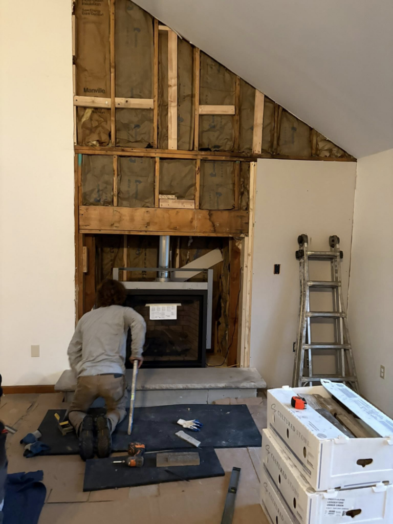 A Cozy Hearth Chimney technician installing a fireplace insert into a framed chimney structure in South Avington Township, PA.