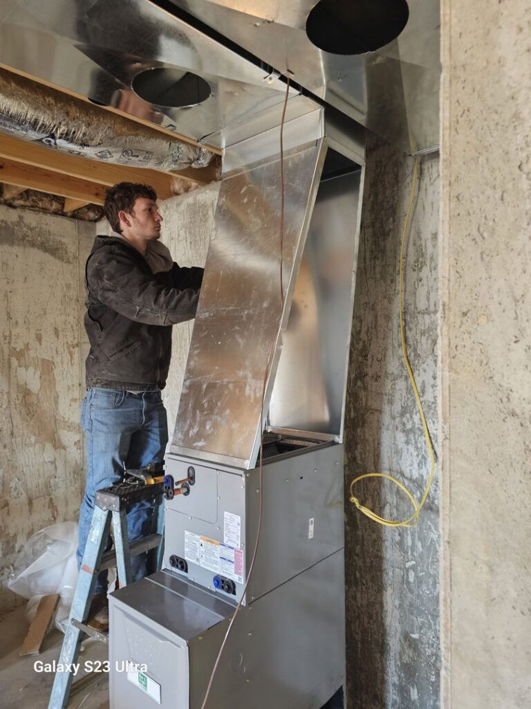 An HVAC technician installing a furnace and ductwork in a basement for Aces of Air Inc. in Georgetown, KY.