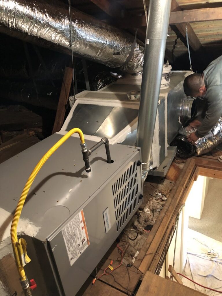 A Tek-Aire Services Inc. technician installing a new furnace and ductwork in an attic space in Columbia, SC.
