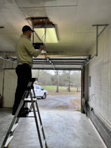 A technician on a ladder installing a garage door opener for Align Garage Door in Ringgold, GA.