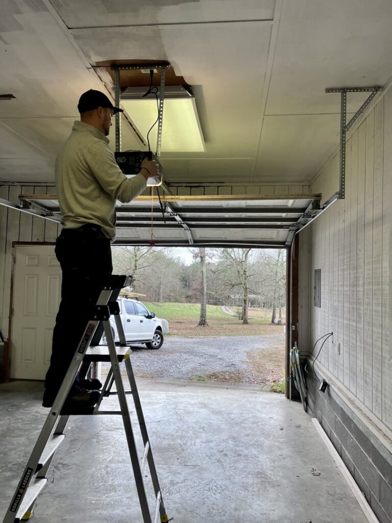 A technician on a ladder installing a garage door opener for Align Garage Door in Ringgold, GA.