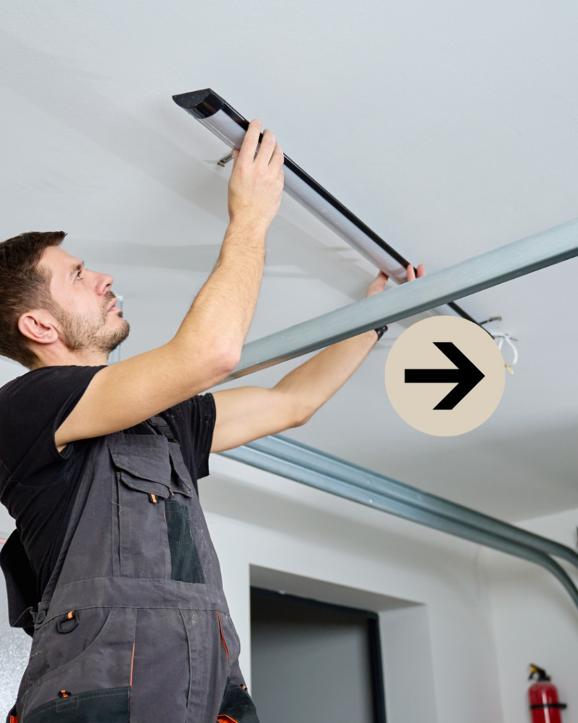A technician in overalls installing a garage door opener rail system for Bayou Overhead Door in West Monroe, LA.