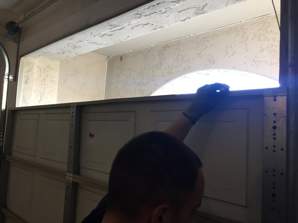 A technician installing a garage door panel during a new installation by Nate's Garage Door Repair in Scottsdale, AZ.