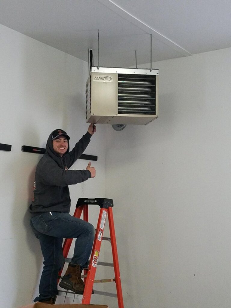 A Crome Mechanical Inc. technician giving a thumbs up after installing a Lennox garage heater in Cedar Springs, MI