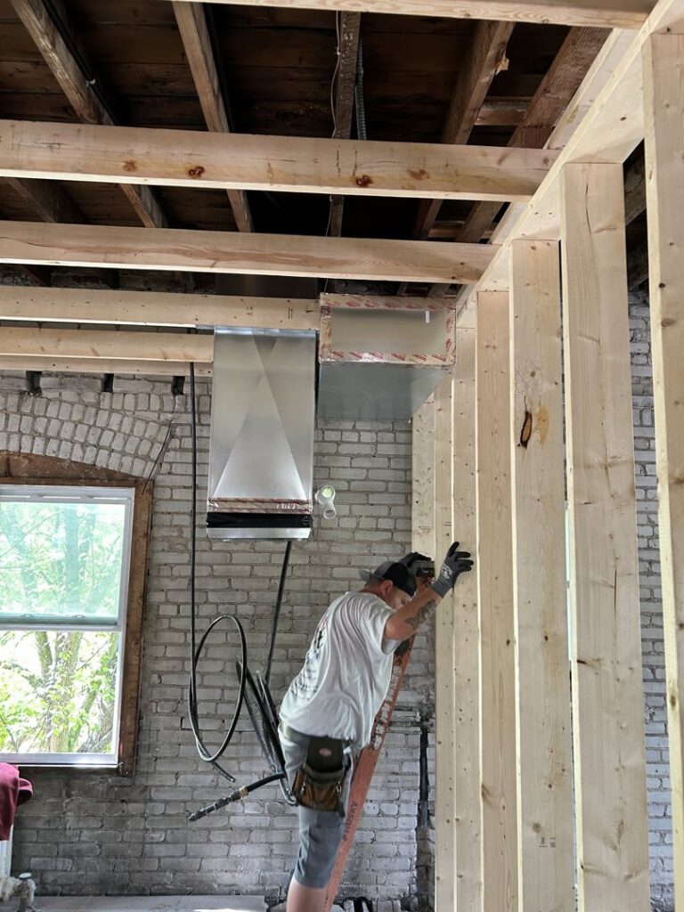 An A&E Heating & Cooling technician installing HVAC ductwork in a new construction in Fort Worth, TX.