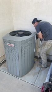 A Hicken Air technician installing or servicing a new Lennox outdoor HVAC unit at a residence in Gilbert, AZ