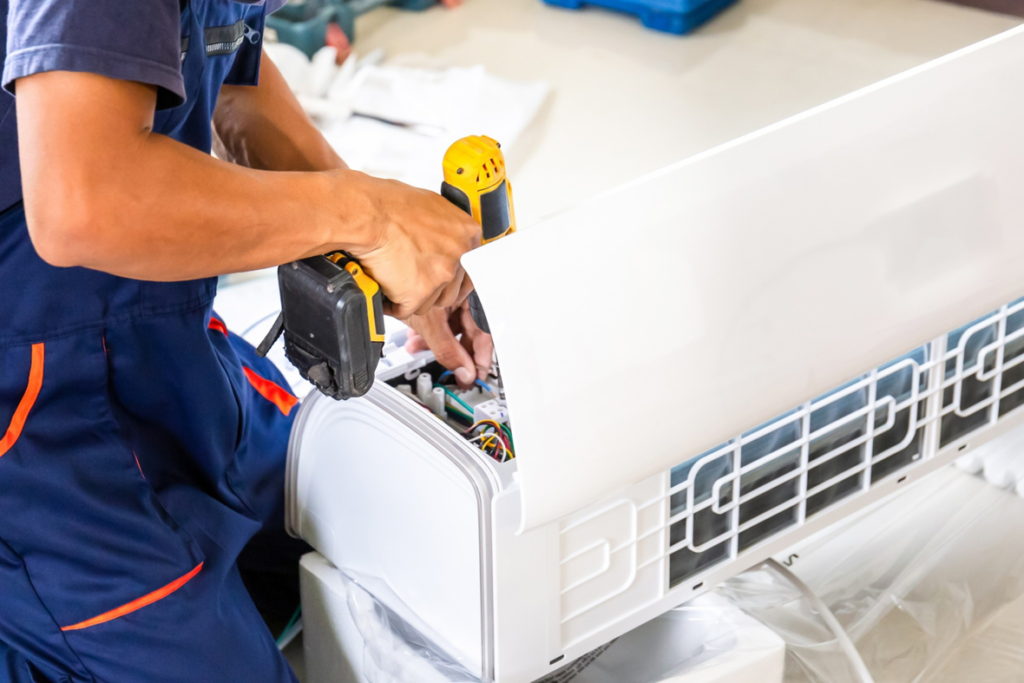 A technician installing or repairing an indoor mini-split air conditioning unit for Chrismon Heating & Cooling in Greensboro, NC.