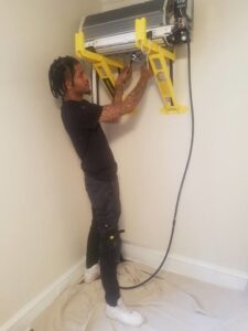 A Daniels HVAC technician installing an indoor mini-split AC unit in Philadelphia, PA.