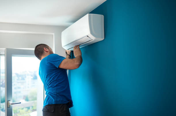 A technician installing an indoor mini-split air conditioning unit for a client of Terry Allen Plumbing & Heating in Flint, MI.