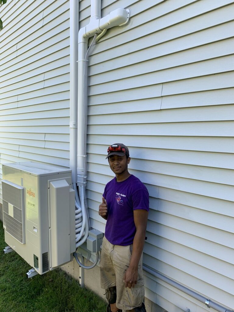 A Hyper Fusion Heating & Cooling technician installing an outdoor mini-split condenser unit in Waterbury, CT.