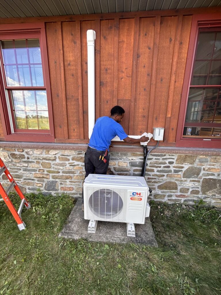 A Zongora Comfort Solutions LLC technician installing an outdoor mini-split HVAC unit in Allentown, PA.