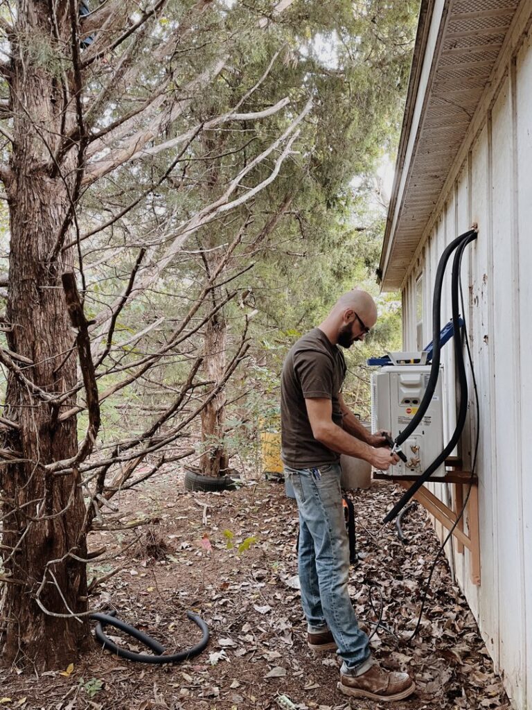 A technician from Davis Heating, Air Conditioning & Home installing an outdoor mini-split unit at a home in Overland Park, KS.