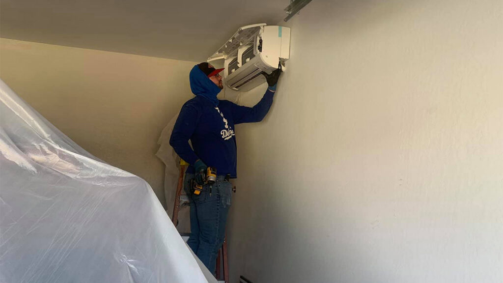 A Lincoln Air & Plumbing technician installing an indoor mini-split HVAC unit in a garage in Phoenix, AZ