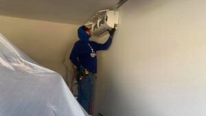 A Lincoln Air & Plumbing technician installing an indoor mini-split HVAC unit in a garage in Phoenix, AZ