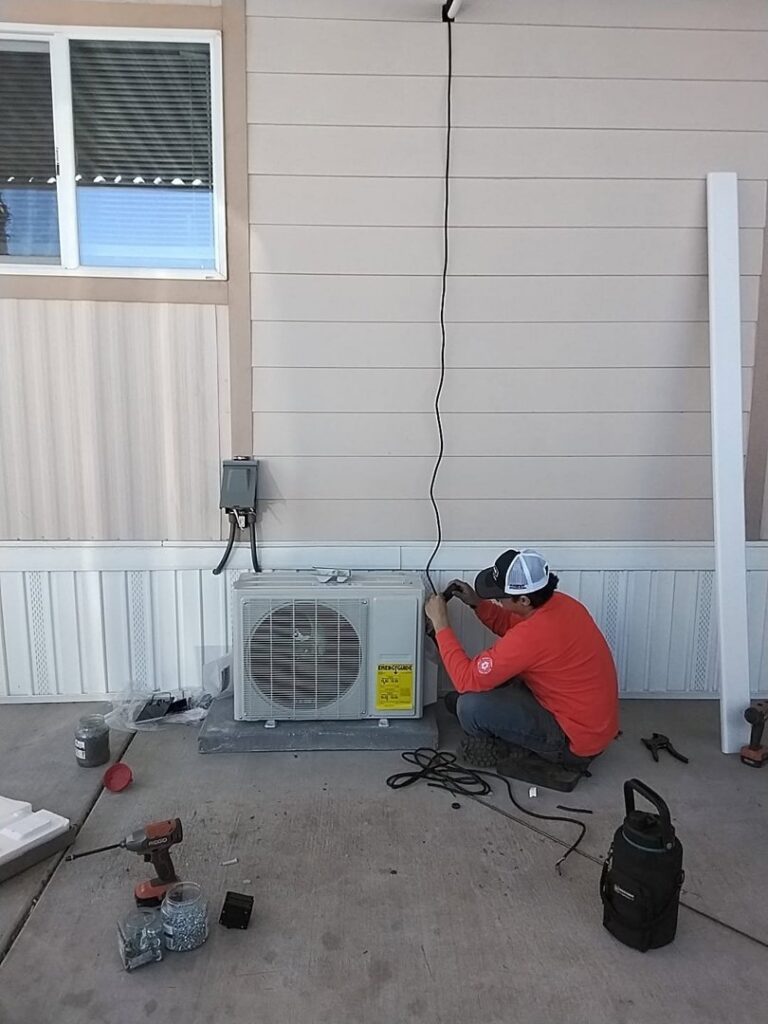 A technician installing or servicing an outdoor mini-split HVAC unit for Heating & Air Paramedics - Tucson in Tucson, AZ.