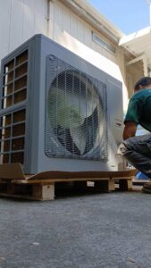 A Gagles Heating technician installing a new outdoor HVAC unit in Salem, OR.