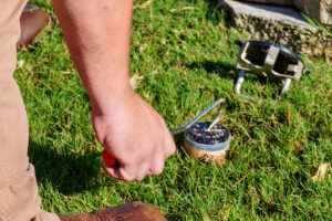 A Pest Magic Pest Control technician installing a pest bait station in a residential lawn in Forsyth, GA.