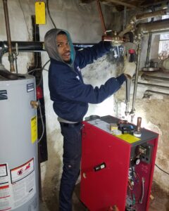 A Daniels HVAC technician installing pipes for a boiler and water heater in Philadelphia, PA.